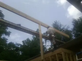 Carpenter setting a ridge beam over a new addition frame — Ice Dam Removal by Roofing Brothers in Mount Holly Springs