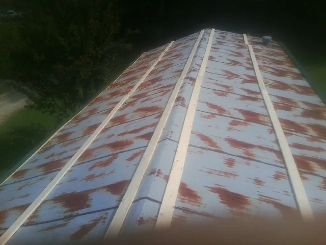 Rusted metal roof panels with new wood purlins before replacement — Storm Damage Roof Repair in Mount Holly Springs by Roofing Brothers