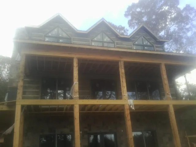 Dormers and porch framing on a large log home under construction — Roof Coating work by our crew in Mount Holly Springs