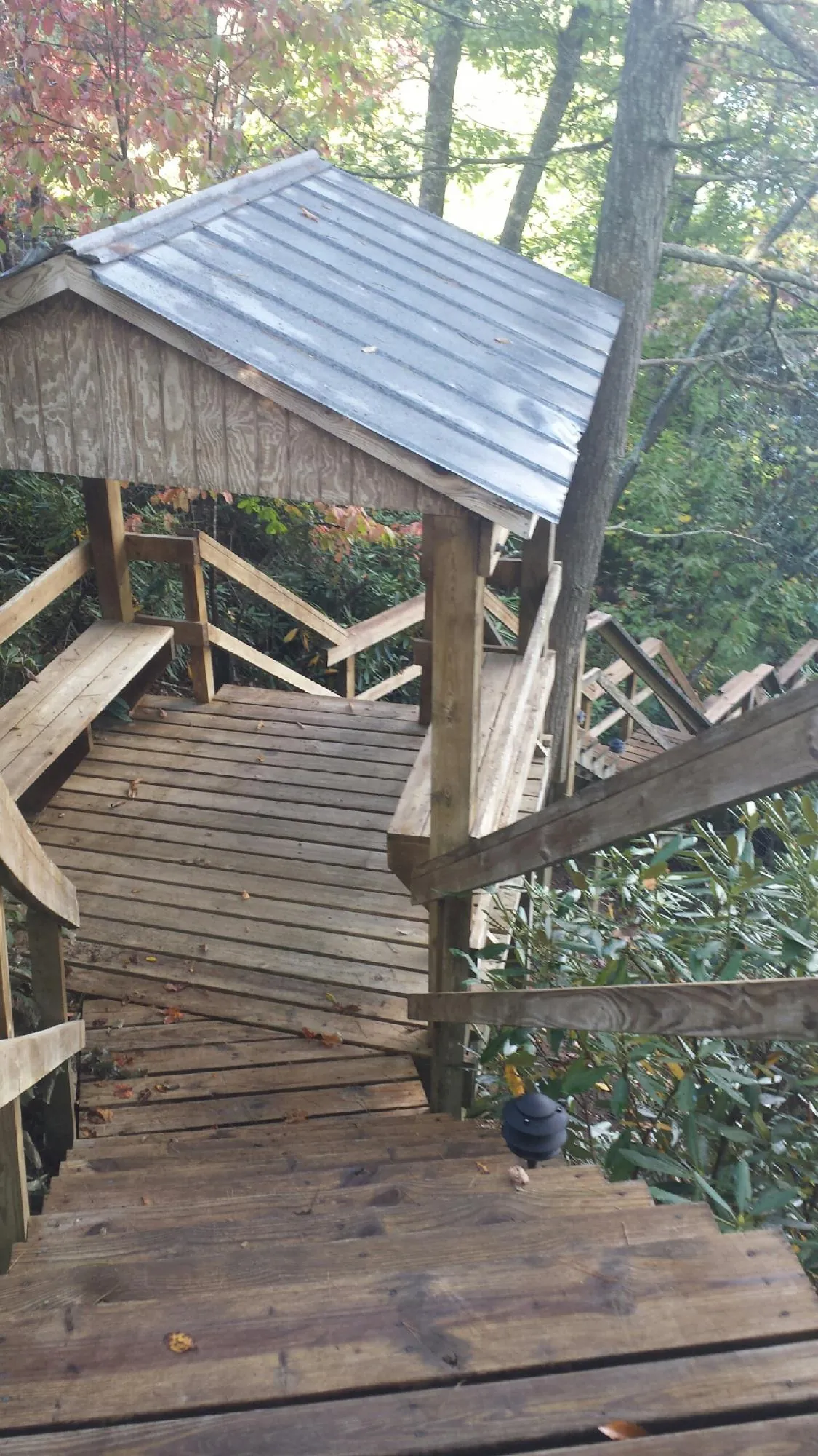 Metal roofed shelter over wooden steps on a wooded walkway — Skylight Repair & Installation work by our crew in Mount Holly Springs