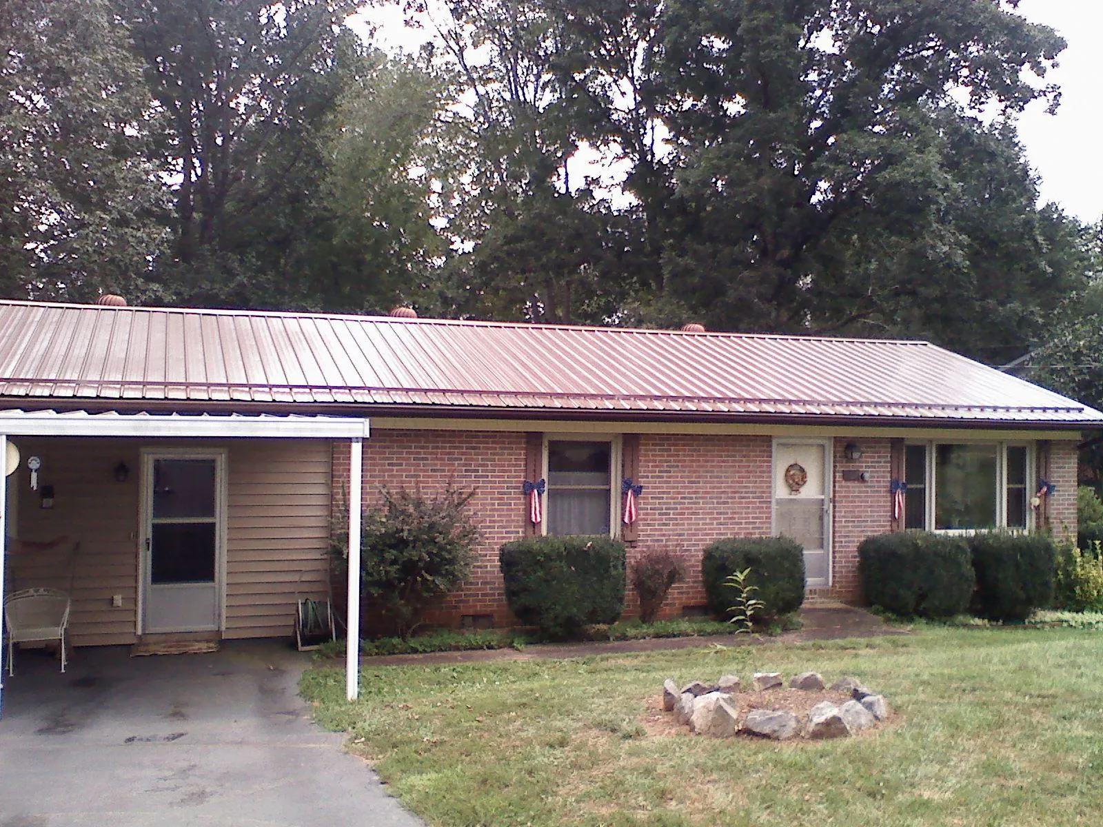 Bronze metal roof and carport on a brick ranch home — Roof Repair work by our crew in Mount Holly Springs